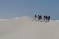 Wandergruppe auf einer Sanddüne.