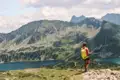Wanderer mit Blick auf Bergsee und Berglandschaft.