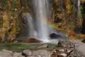 Wasserfall mit Regenbogen und Felsen