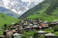 Bergdorf mit Wehrtürmen im Kaukasus vor der Kulisse schneebedeckter Berge.
