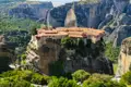 Ein historisches Kloster in Meteora, erbaut auf einem hohen Felsen, mit Blick auf die umliegende Landschaft.