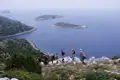 Wandergruppe auf einem Küstenpfad mit Blick auf das Meer und vorgelagerte Inseln.