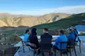 Gruppe von Reisenden entspannt sich auf einer Dachterrasse und genießt den Ausblick auf die Berglandschaft.