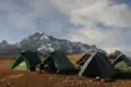 Zeltaufbau im Basislager vor einer Bergkulisse.
