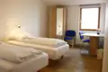 Zimmer mit zwei Einzelbetten, Kleiderschrank und Schreibtisch - ideal für Reisende.