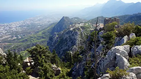 Aussicht von den Bergen auf die Küste und eine mittelalterliche Burgruine.