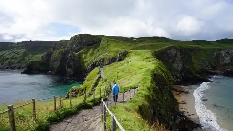 Wanderweg auf einer grünen Klippe entlang der Küste.