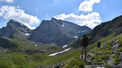Wanderer auf einem Bergpfad mit Blick auf die Gipfel.