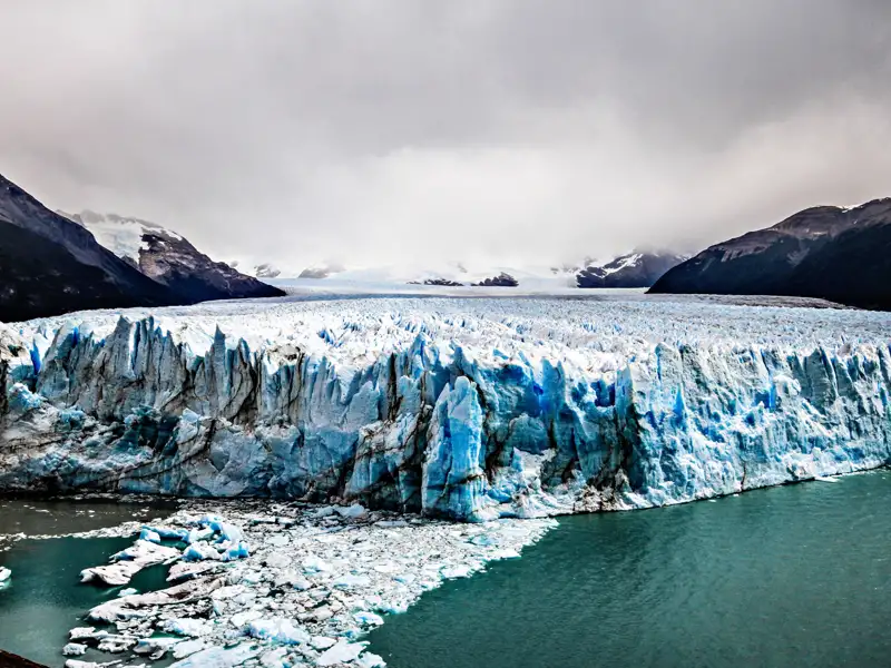 Der Perito-Moreno-Gletscher kalbt ins Wasser und zeigt seine mächtigen Eiswände.