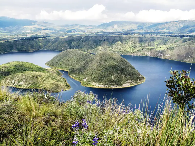 Panoramablick auf den Kratersee mit seinen bewaldeten Inseln und der umliegenden Landschaft.