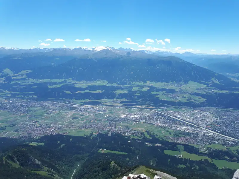 Panoramablick vom Gipfel auf das Tal und die Bergkette.