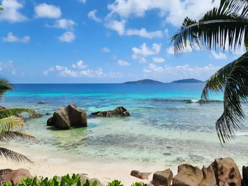 Türkisfarbenes Wasser, weiße Sandstrände und Granitfelsen – ein typischer Strand auf den Seychellen.