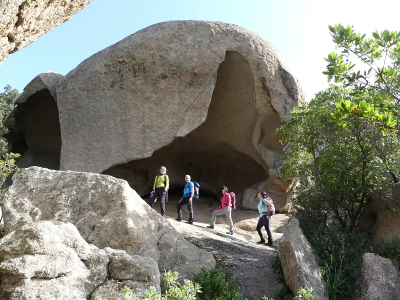 Wanderer erkunden einen großen Felsvorhang auf ihrer Wanderung.