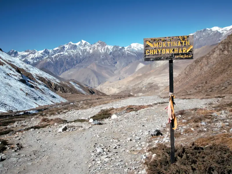 Wegweiser mit den Ortsangaben Muktinath und Chhyonkhar auf einer Trekkingroute im Himalaya.