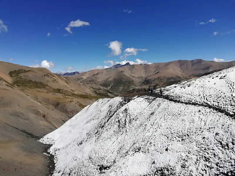 Wanderer auf einem schneebedeckten Bergpfad in den Bergen.