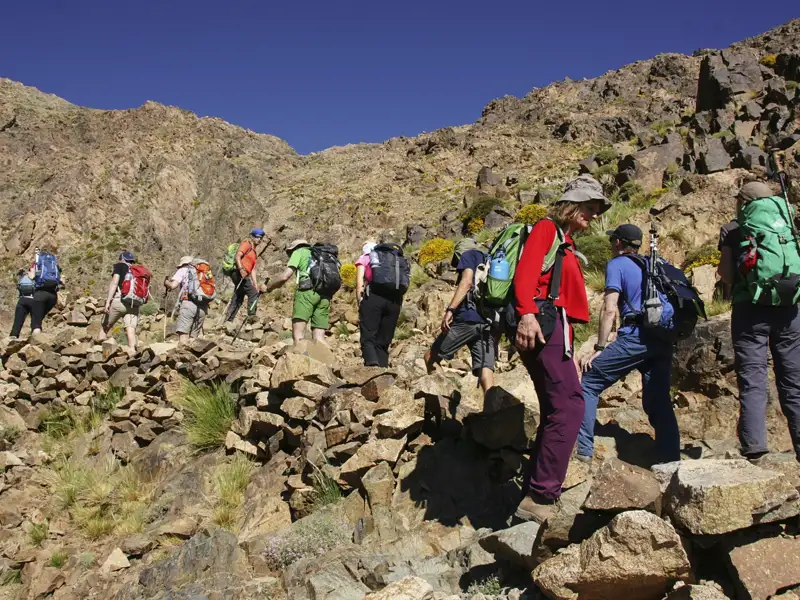 Wandergruppe auf einem steinigen Bergpfad.