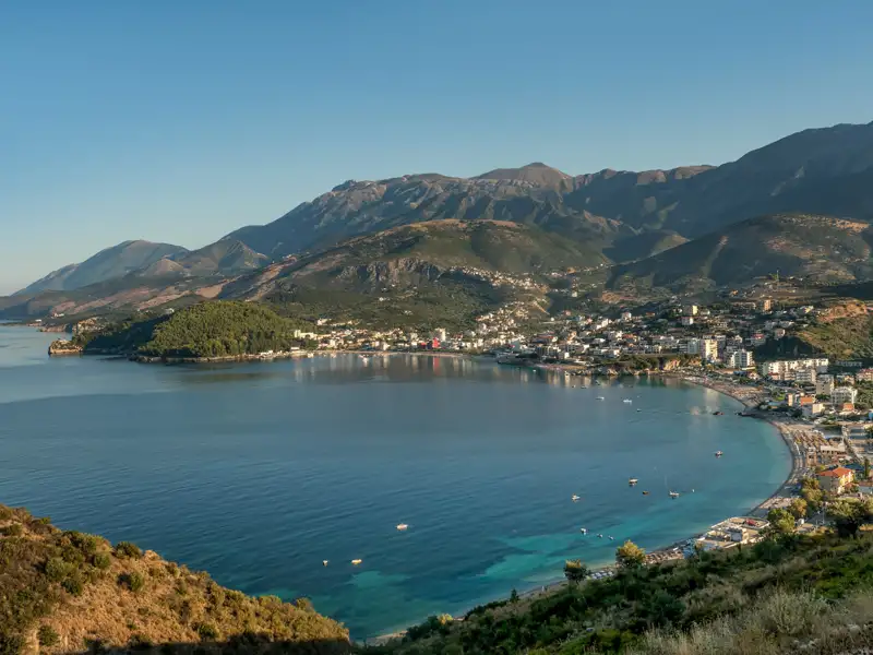 Panoramablick auf die Küstenstadt und die Bucht mit Bergen im Hintergrund.