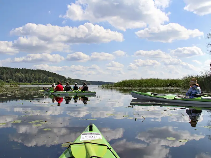 Kajaks auf einem See mit Wolkenreflexion.