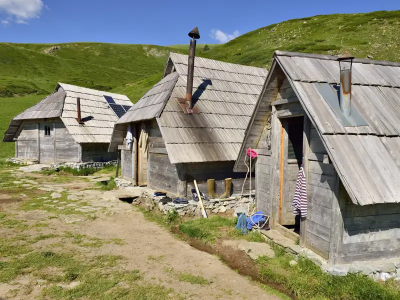 Unterkunft: Rustikale Holzhütten mit Schindeldächern und Kaminen. Eine Hütte nutzt Solarenergie.