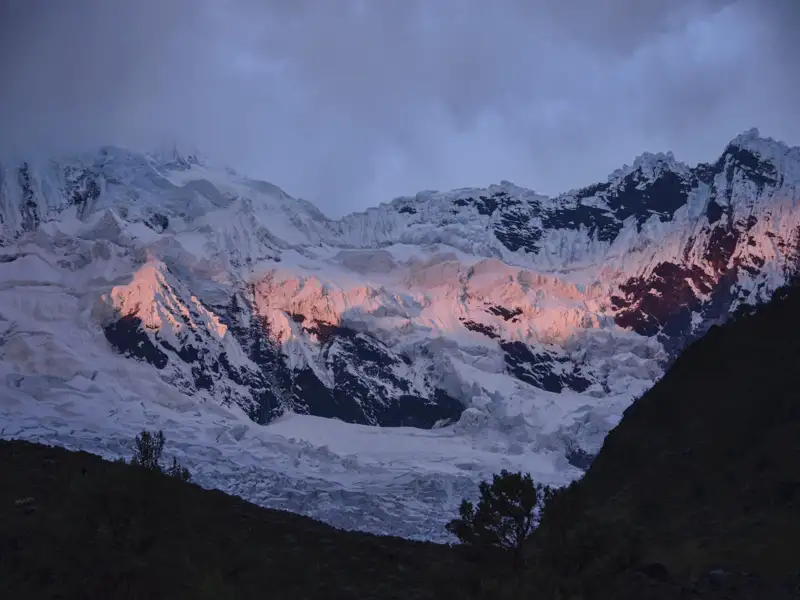 Schneebedeckte Berglandschaft im Abendlicht.