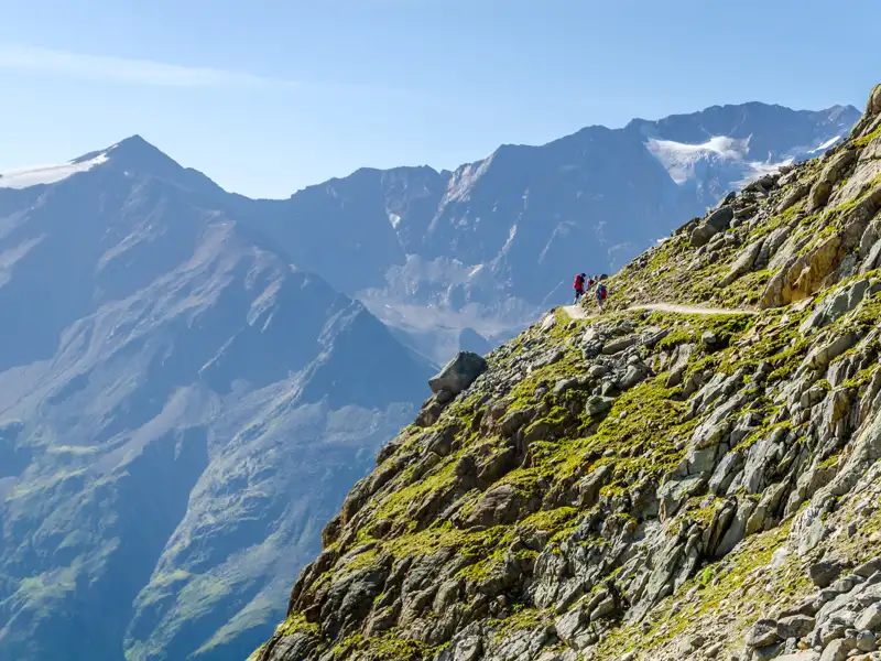 Wanderer auf einem Bergpfad in den Alpen.
