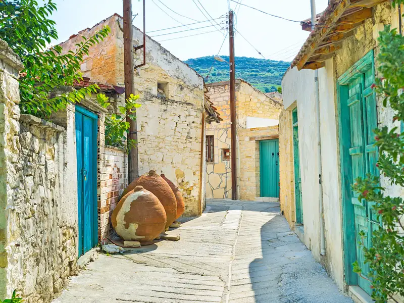 Eine traditionelle Gasse mit Steinhäusern und Tonkrügen.
