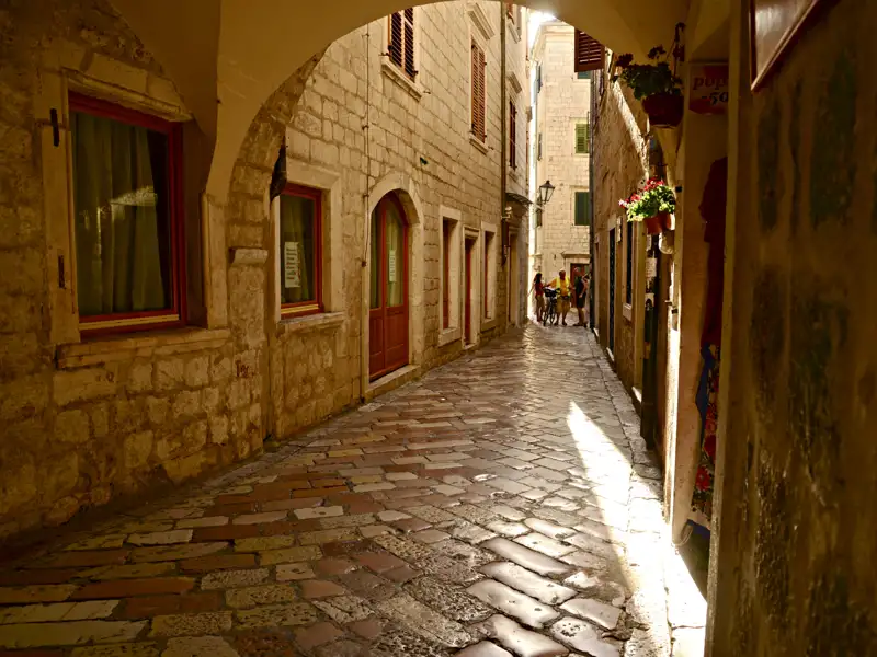 Schmale Gasse mit Kopfsteinpflaster und historischen Gebäuden.