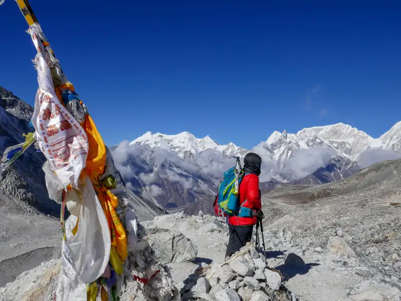 Wanderer auf einem Bergpfad mit Blick auf schneebedeckte Gipfel.