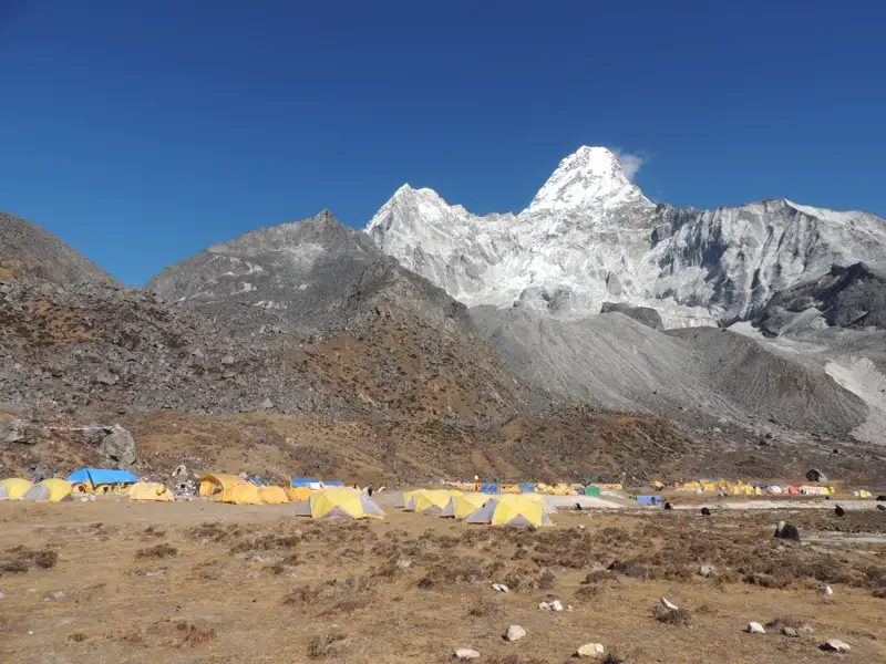Basislager mit Zelten am Fuße eines schneebedeckten Berges.