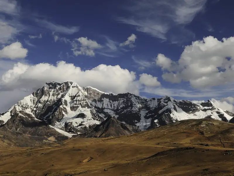Ansicht einer schneebedeckten Bergkette und des umliegenden Hochlandes.