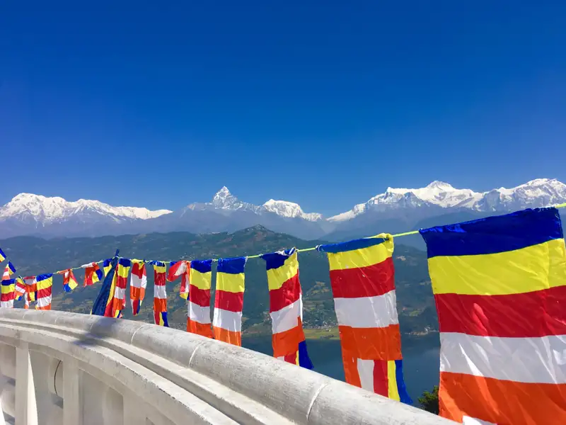 Bunte Gebetsfahnen vor dem Panorama der schneebedeckten Himalaya-Berge.