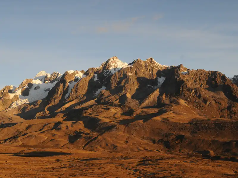 Schneebedeckte Bergkette in einer kargen Landschaft.
