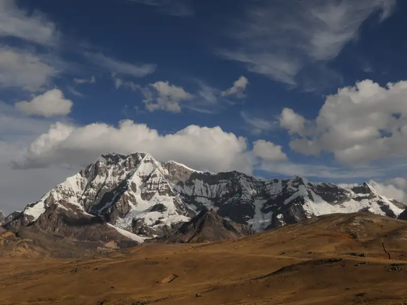 Schneebedeckte Bergkette in einer trockenen Landschaft.