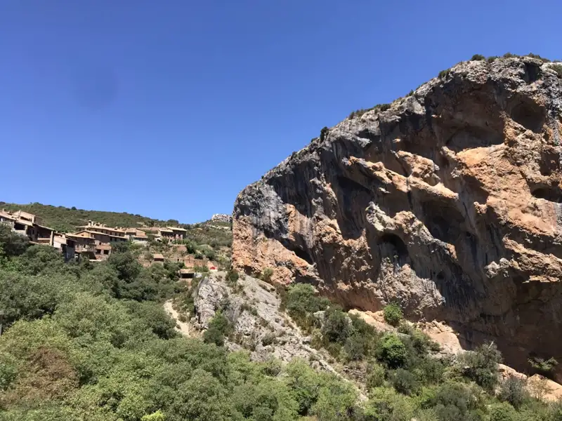 Dorf am Fuße einer Felswand