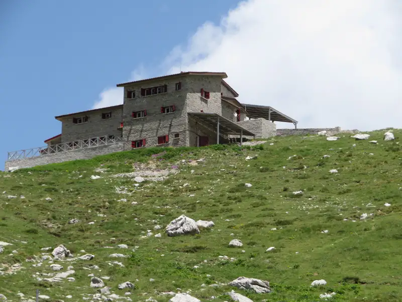 Steinhaus auf einem bewachsenen Hügel, möglicherweise Teil der Reiseunterkunft oder eine Station entlang der Route.