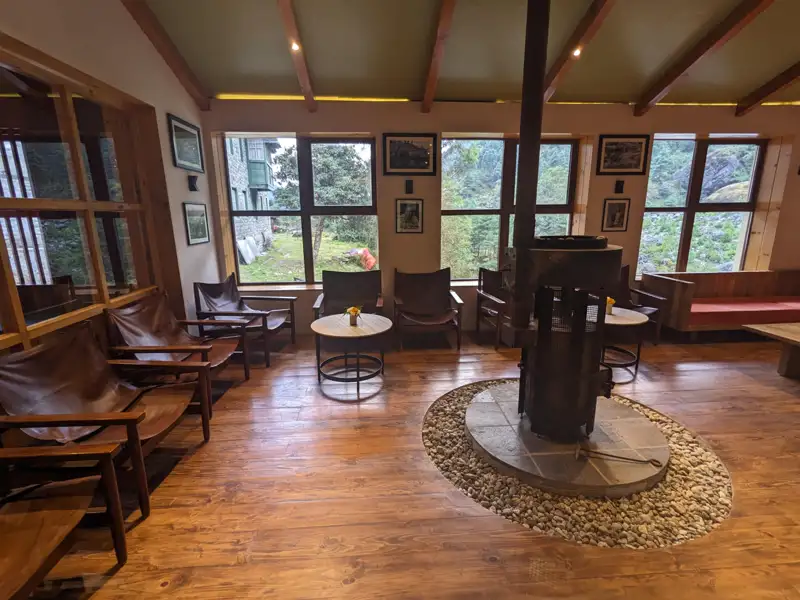 Gemütlicher Aufenthaltsbereich mit Kamin und Blick auf die Landschaft.