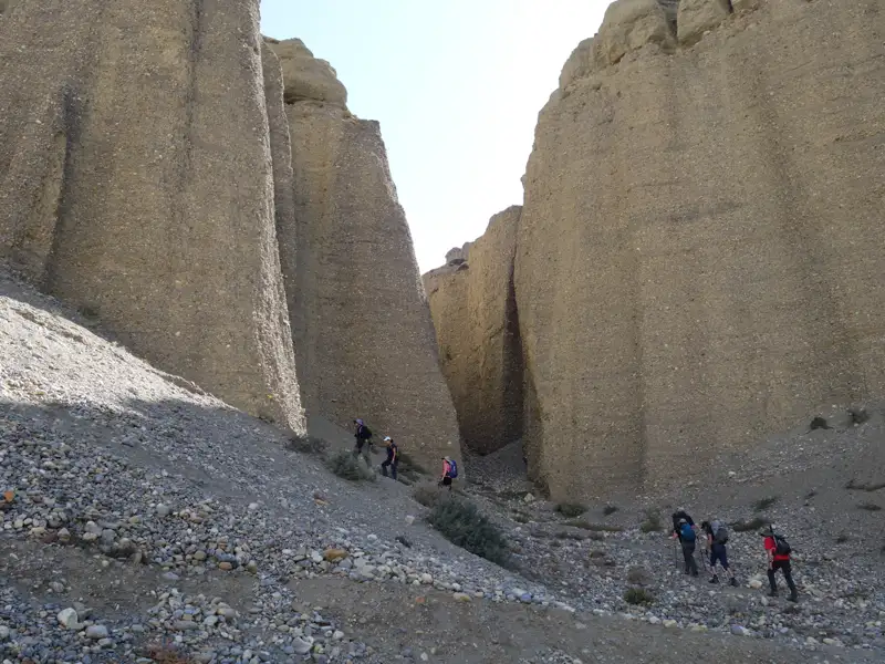 Wanderer auf einem steinigen Pfad in einer engen Schlucht.