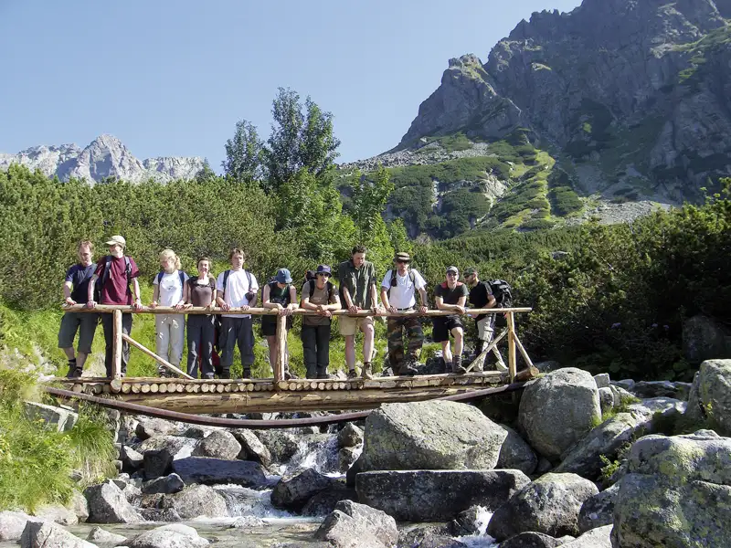 Wanderer auf einer Holzbrücke in den Bergen.