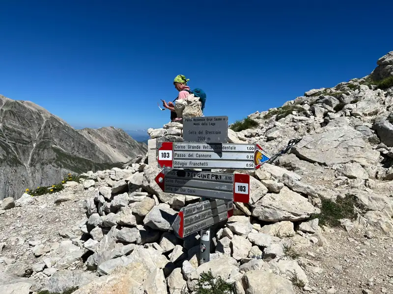 Wegweiser mit Entfernungsangaben zum Corno Grande, Sella del Brecciaio und Rifugio Franchetti in den italienischen Bergen.