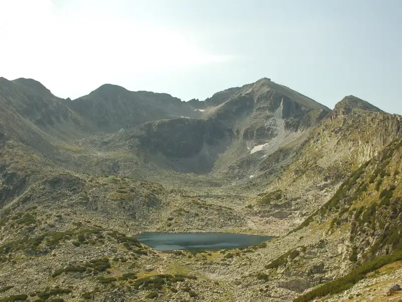 Blick auf einen Bergsee und die umliegenden Gipfel.