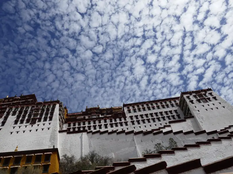 Der Potala-Palast, ein historisches Wahrzeichen in Tibet, unter einem beeindruckenden Wolkenhimmel.