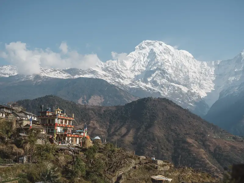 Bergdorf in den Himalayas mit Blick auf schneebedeckte Gipfel.