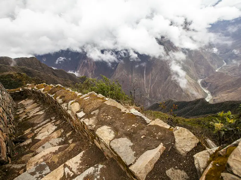 Steintreppe auf dem Inka Trail mit Blick auf das Urubamba-Tal und die umliegenden Berge.