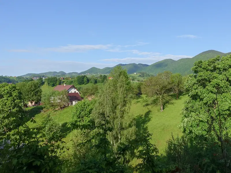 Idyllisches Bauernhaus in einer grünen Hügellandschaft.