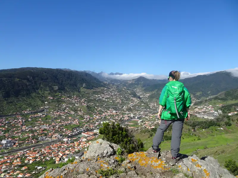 Wanderer auf einem Berg mit Blick auf das Tal.