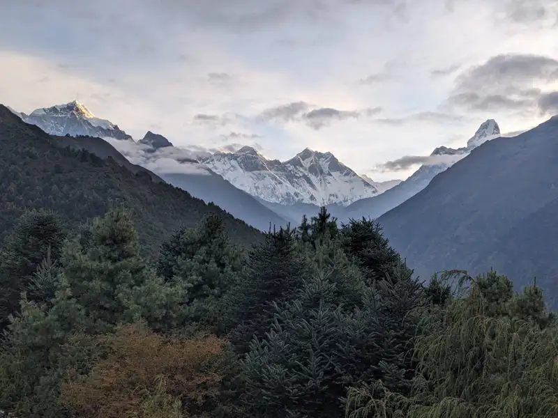 Schneebedeckte Gipfel und bewaldete Hänge.