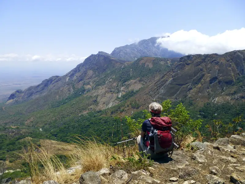 Wanderer pausiert und genießt den Panoramablick auf die Berglandschaft.