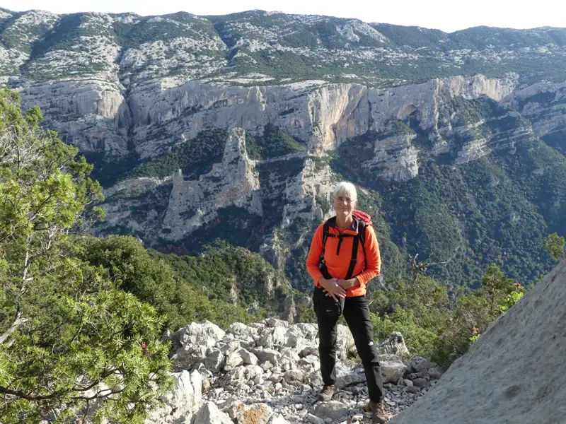 Wanderer auf einem Bergpfad mit Blick auf eine Schlucht.