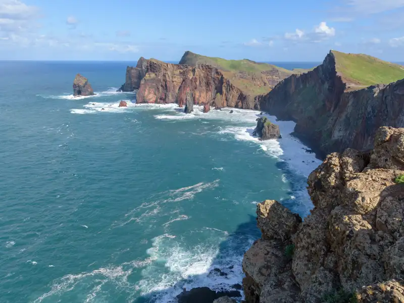 Felsige Küstenlinie mit dramatischen Klippen und Wellen.