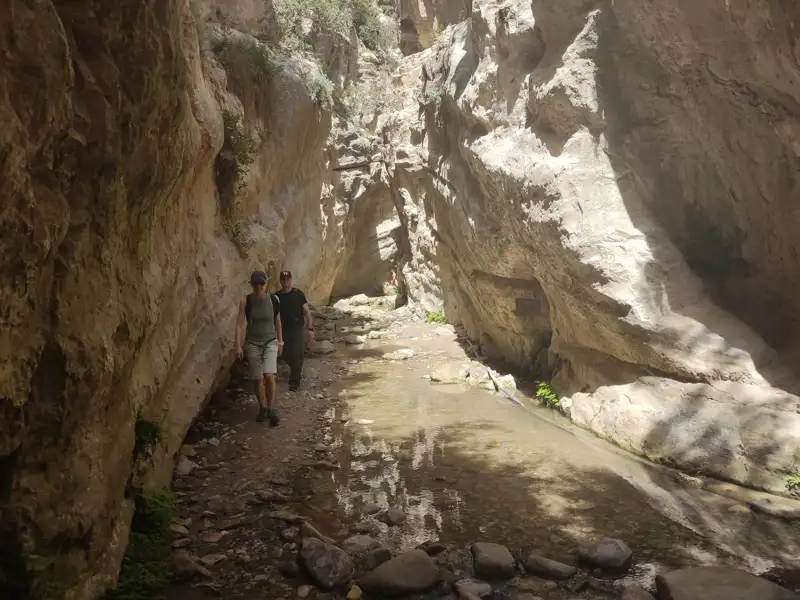 Zwei Wanderer erkunden eine Schlucht.